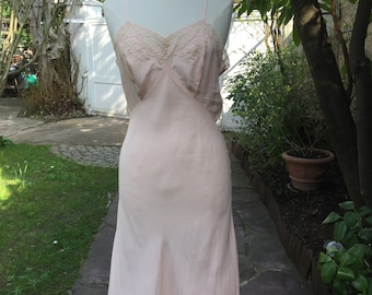 1930's 100 percent pale pink silk slip dress with beautiful antique lace detail around the décolleté. Size medium.