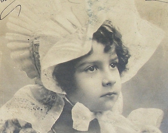 1900s French postcard, Girl in a bonnet, RPPC paper ephemera. Real photo postcard.
