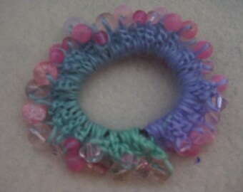 Crocheted soft purple and green hairband with various pink and clear beads