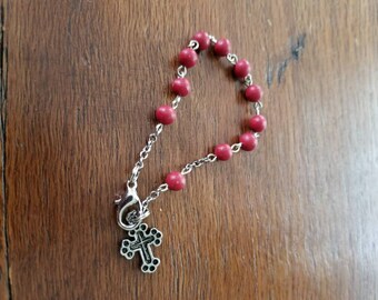 Rosary bracelet....reddish beads....cross...silvertone