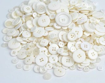 25 buttons in different sizes in shades of white