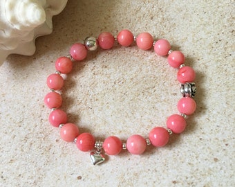 Charming pink coral stretch bracelet with decorative elements and a heart charm, natural stone bracelet