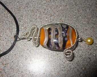yellow black and silvered ivory glass focal bead wire wrapped into a pendent lampwork
