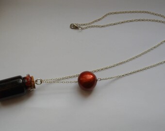 blood vial and metalisee red ball necklace