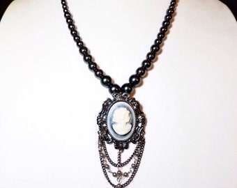 Hematite Pearl Cameo Necklace: 21.5" hematite Czech glass pearl necklace with dangly cameo pendant. Portion of sale goes to charity.