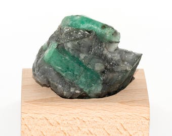 Rough emerald on base of beech wood of 113 grams.