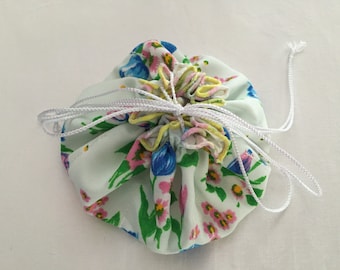 Floral Jewelry Bag with 8 Sheer Pockets Blue Floral Print, White Sateen inside, White Iridescent Drawstrings 6" across when closed Hand Made
