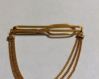 Vintage signed Swank gold tone cravat holder with a triple chain.