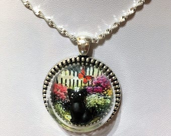 Black Cat in garden, white picket fence and flowers antique silver necklace glass globe