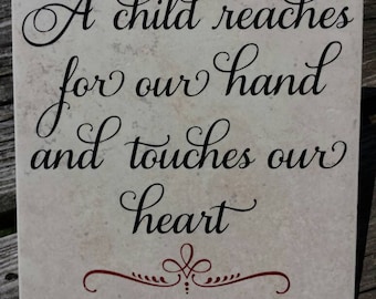 A child reaches for our hand and touches our heart decorative ceramic tile 6x6