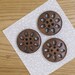 Wooden button, dark brown colour with sun / flower design, pack of 6