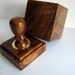 The sealing wax press in a case from a natural tree with the image of the family coat of arms