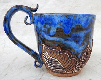 Stoneware mug with carving and slip decoration