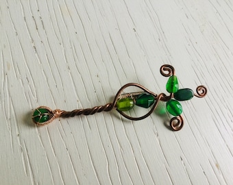Brooch of copper wire and green glass beads