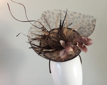 Leopard print sinamay with leopard print crin, sinamay loops, orchid fabric flowers and feathers along with curled quills