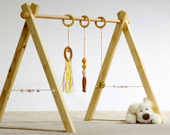 Montessori Baby gym Playset of awakening, pale orange and yellow version 3 rattles, spheres in wood on the sides.