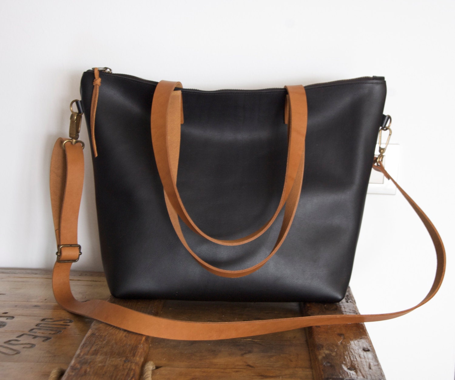 Medium Black Leather bag with zip and brown leather straps.
