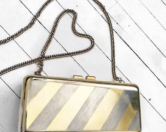Small gold and silver striped metal hard shell evening bag.