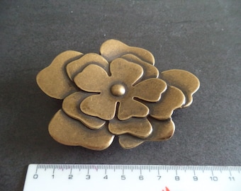 bronze colored metal belt buckle in flower shape