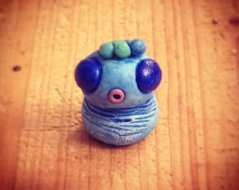 Blue Monster mini sculpture and his crest