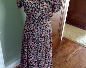 Vintage dress with pink roses...black background...front buttons....fitted at the waist.