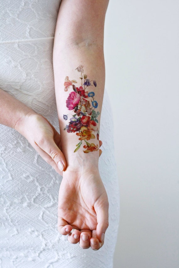 Realistic flower tattoos on the right forearm.