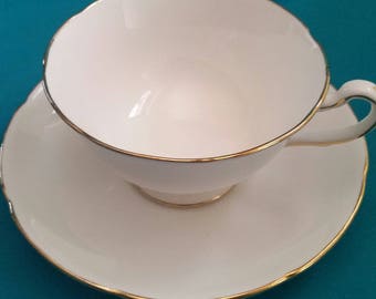 white and gold cup and saucer