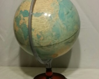 Vintage world globe sitting on wood stand.