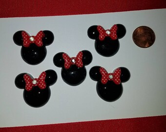 Minne Mouse like with black with a red white Polk a dot bow and rhinestone in the middle. Embellishments, scrapbooking, hair bow, crafts.