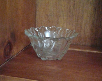 Small clear glass bowl with flower design in bottom and leaves up sides