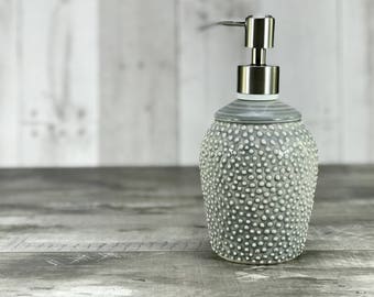 Grey soap dispenser. Porcelain soap dispenser. Ceramic soap dispenser. Grey bathroom. Gray bathroom. Textured pattern. Brushed nickel pump.