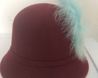 Burgundy cloche hat with blue feathers