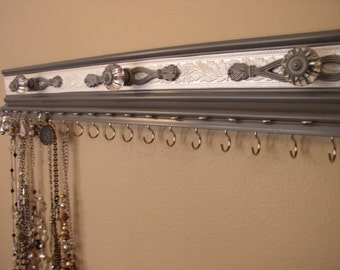 Jewelry organizer for both necklaces and earrings in gray. This wall rack is both functional and pretty, with 19 hooks