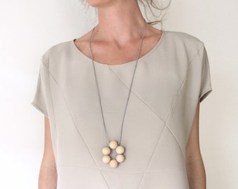 geometric necklace with natural wooden beads on a gray leatherstring