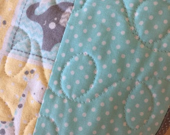 Patch work elephant print in cotton flannel.the backing is a aqua,,white flannel,and Machine quilted by me. An heirloom quality quilt.