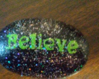 Believe on black river rock with sparkles