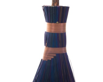 Handmade turkey wing broom featuring a rustic handle with carving at the top and multi-colored bristles.