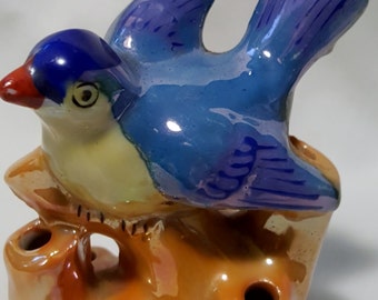 A vintage blue bird perched on a limb