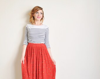 novelty tiny fishermen print skirt . 80s red silk pleated people pattern midi .small.medium .sale