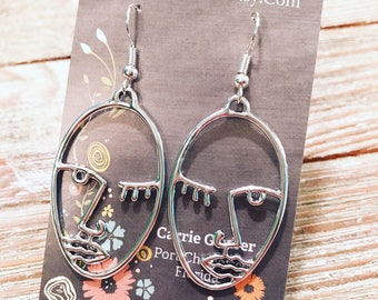Silver tone Picasso face earrings on nickel free ear wires.