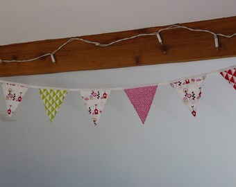 Garland of seven pennants in shades of red, pink.