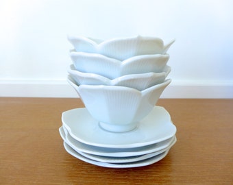 Quatre bols de lotus blanc avec soucoupes correspondant