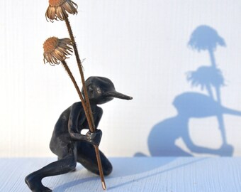 Bronze sculpture of female figure with hummingbird head