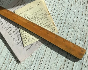 Vintage 15 inch wooden ruler with metal cutting edge, useful vintage studio item. No maker's markings but nice patina and colour.