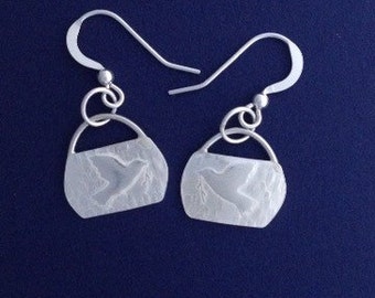 Peace dove dangle earrings in sterling silver. Textured to catch the light.