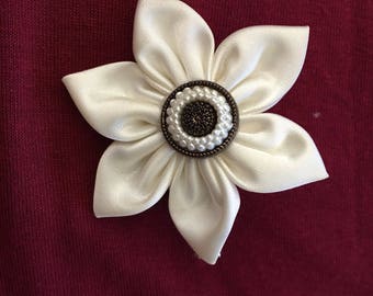 Small white satin flower on alligator clip.