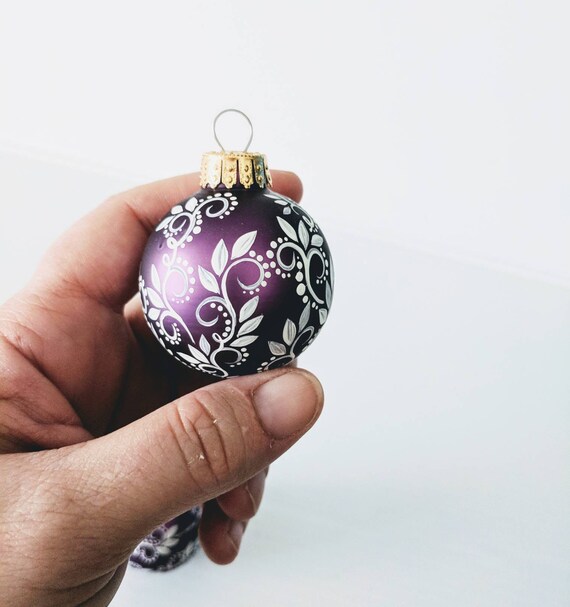 Tiny little ornaments white swirls leaves and dots on small plum purple glass ornaments