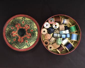 vintage tin with sewing threads on wooden spools