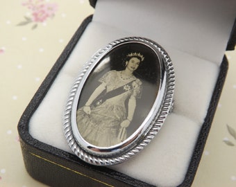 A 1950s hand made Queen Elizabeth II vintage jewelry brooch showing the young Queen in formal dress. Made to celebrate the Coronation