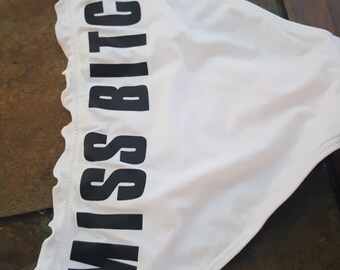 MISS BITCH ruffle top bikini bottoms written in big black letters across the back